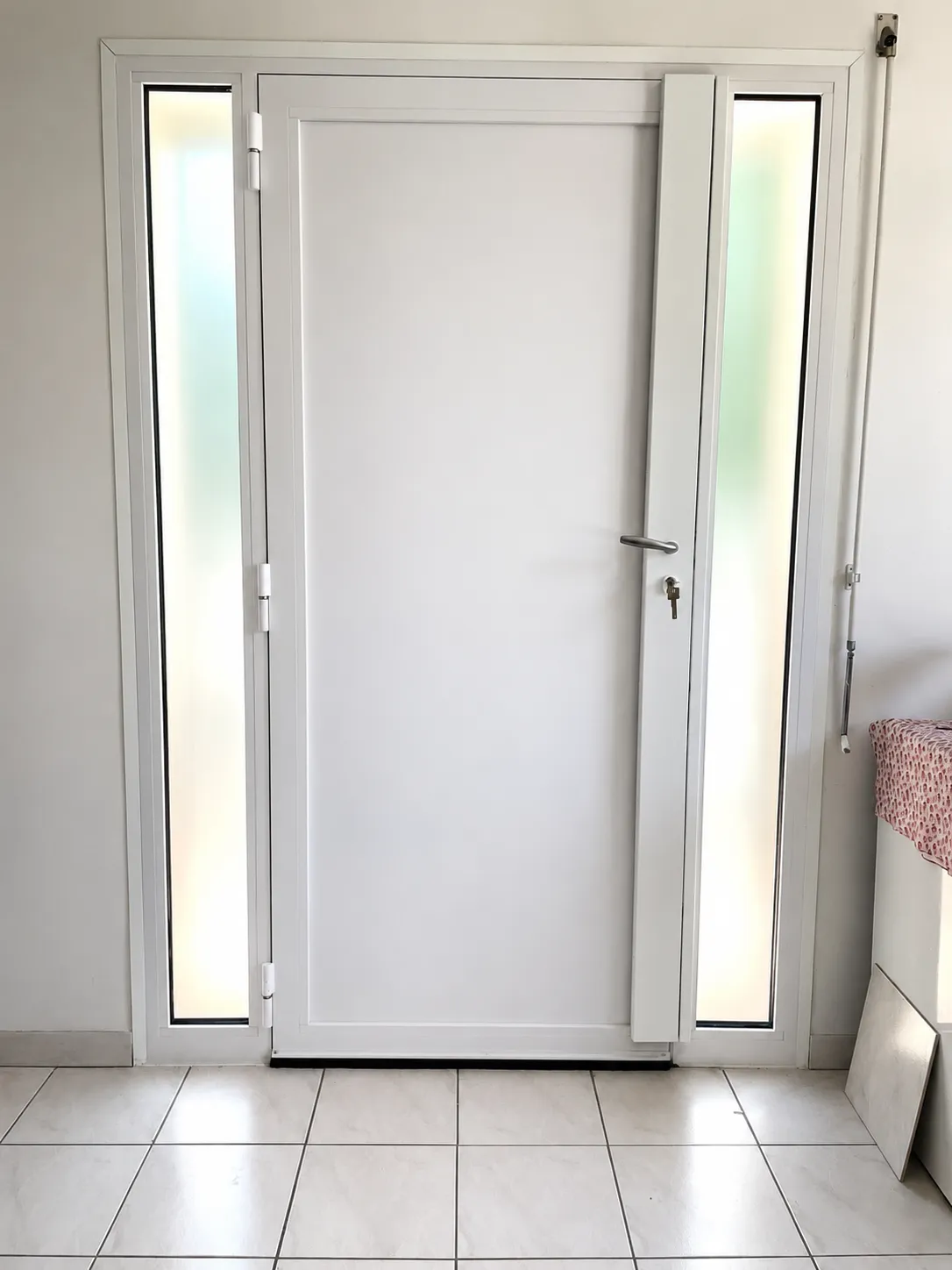 Installation de porte d'entrée PVC blanche avec panneaux latéraux vitrés à Angers — TD Serrurerie