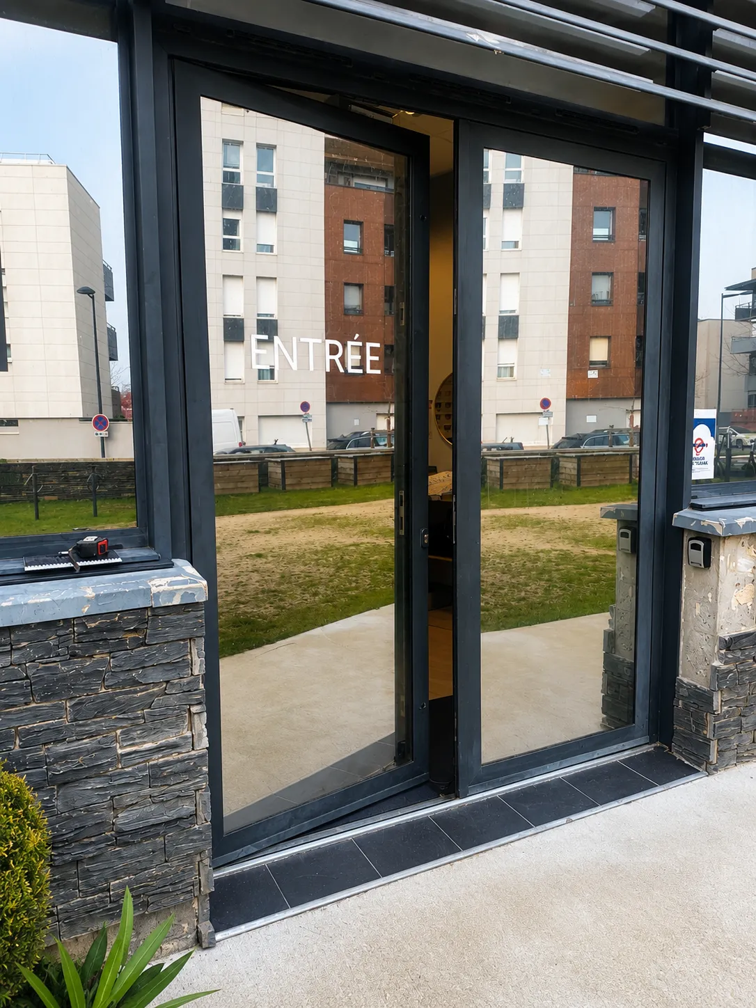 Porte d'entrée vitrée en aluminium noir posée dans une résidence à Angers — TD Serrurerie